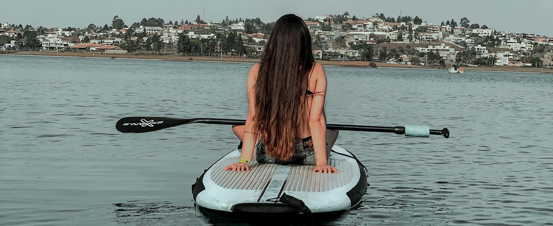 Woman paddle boarding using a soft top paddle board
