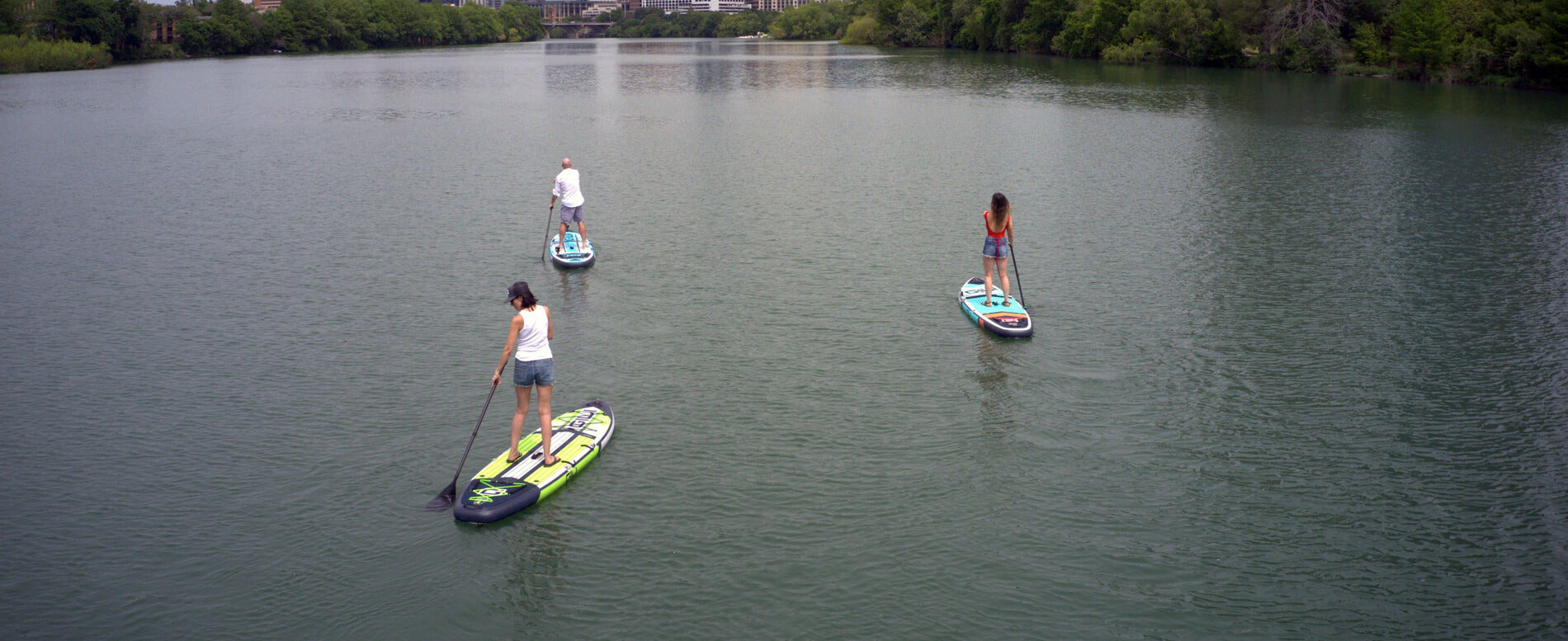 Man and a woman paddle boarding on a river